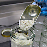 Powder is filled into a jar with a scoop.